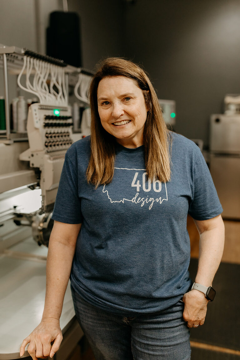 Jennifer Williams, embroidery and retail sales at 406 Design, by the embroidery machines