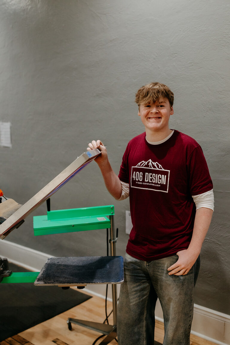 Dylan Claver, screen printer at 406 Design, at the screen printing press